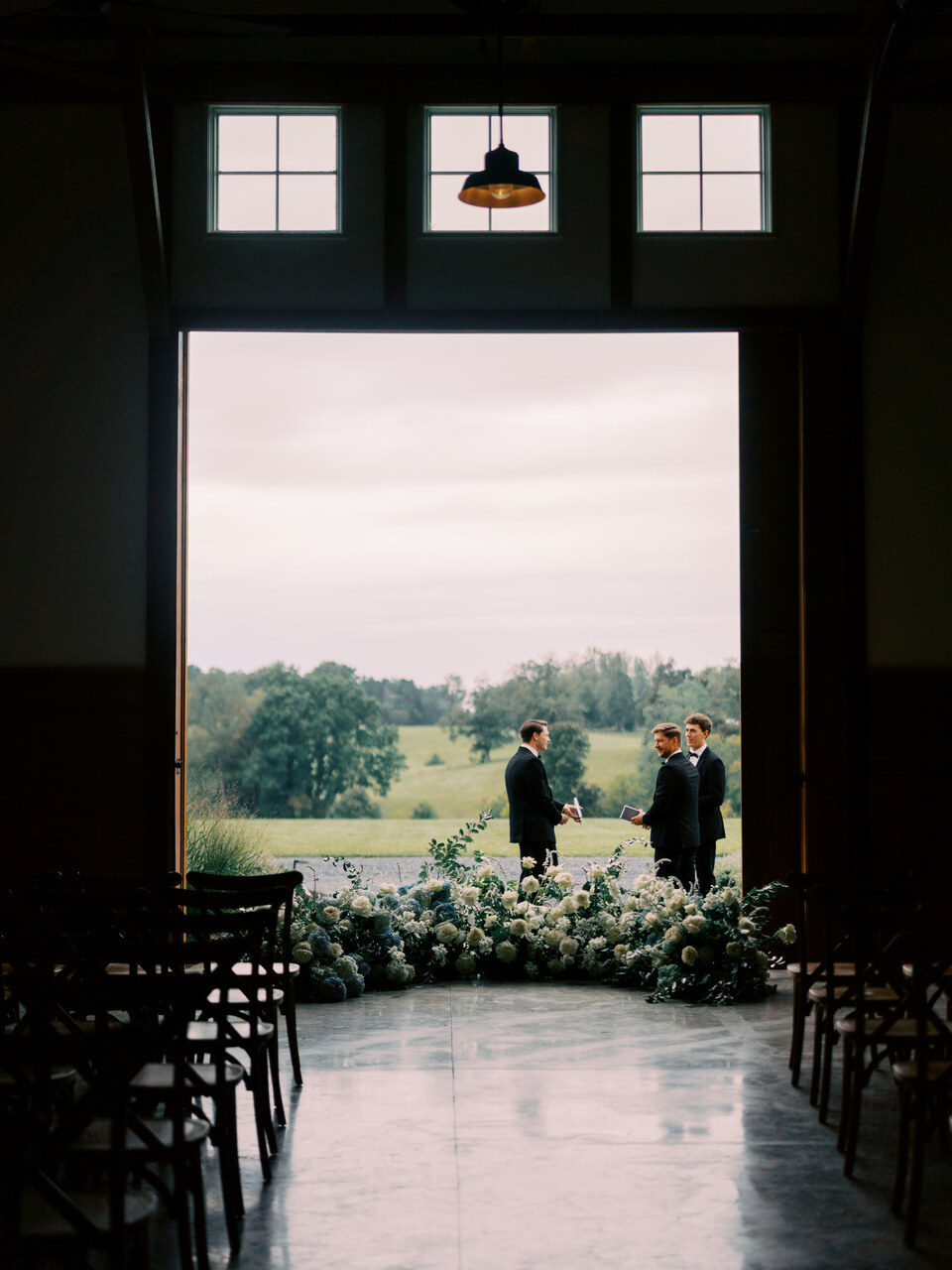 Looking out through the open barn doors to a couple and the pasture